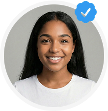 Smiling young woman with long dark hair wearing a white shirt, with a blue verified checkmark badge in the top right corner.
