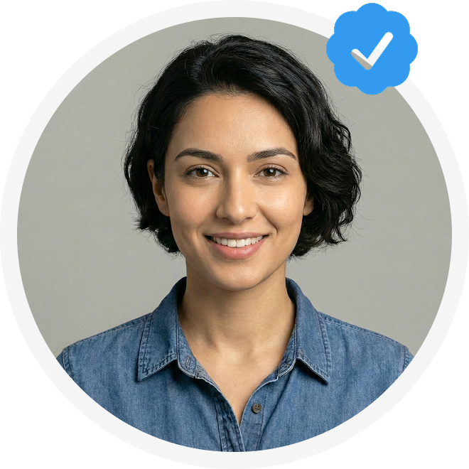 Smiling woman with short dark hair wearing a denim shirt, framed in a circular border with a blue verified checkmark icon.